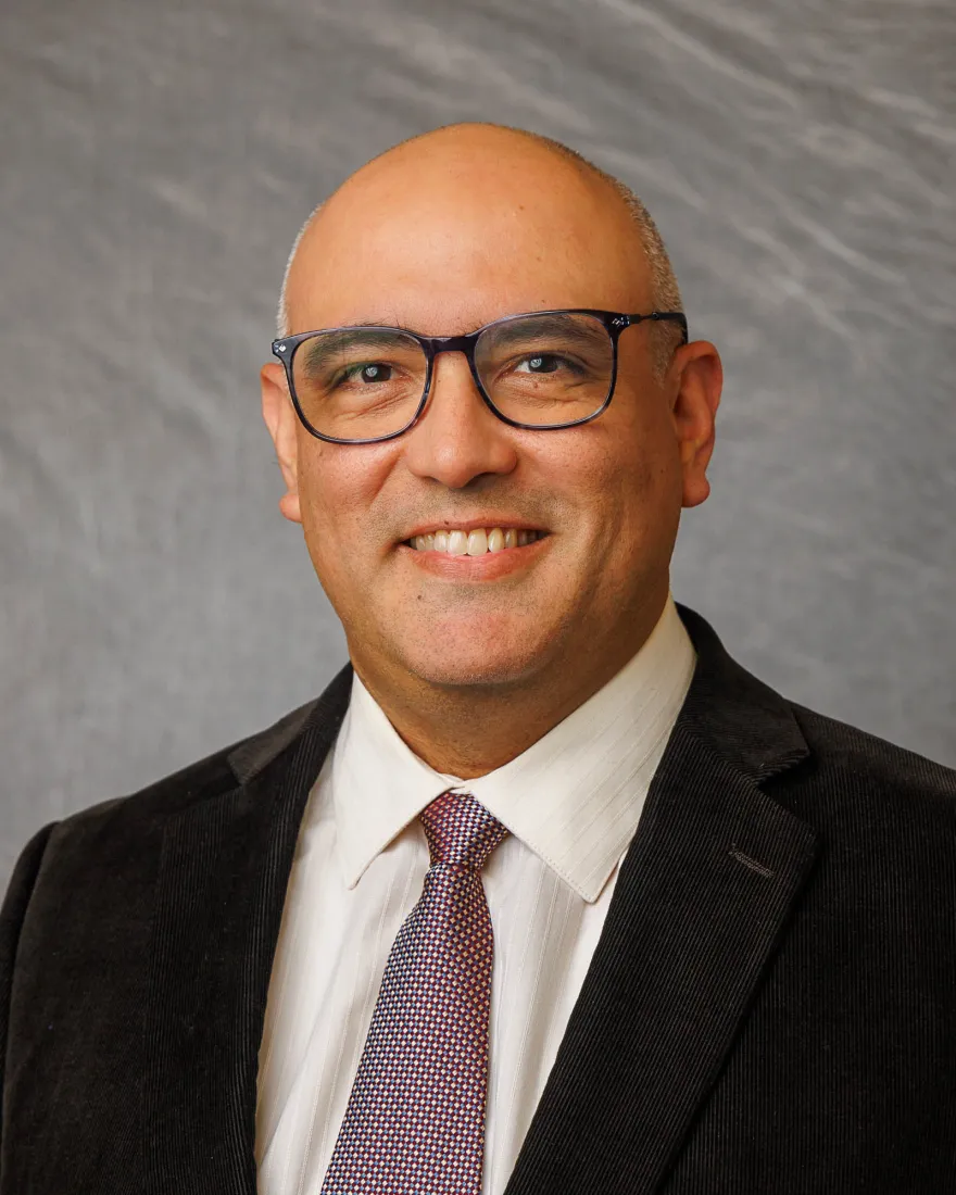 Picture of Carlos Jarro, He is a slightly overweighted bald man wearing glasses. His round face and smile make him look approachable.
